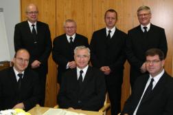 Bezirksapostel Nadolny (m), Bezirksältester <br/>Härm (l), Bezirksevangelist Jäger (r) sowie<br/> die weiteren Amtsträger im Ämterzimmer. Bezirksapostel Nadolny (m), Bezirksältester <br/>Härm (l), Bezirksevangelist Jäger (r) sowie<br/> die weiteren Amtsträger im Ämterzimmer.